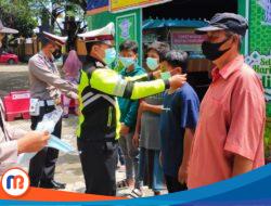 Demi Menjaga Kesehatan Masyarakat, Satlantas Polres Sampang Bagikan Masker kepada Pengunjung Wisata Pantai Camplong