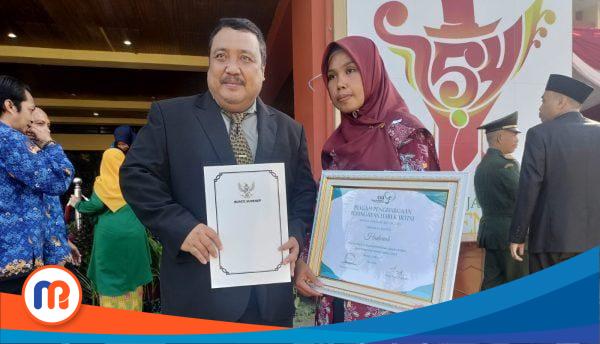 Kepala Dinas Sosial Pemberdayaan Perempuan dan Perlindungan Anak (Kadinsos P3A) Kabupaten Sumenep, Drs. Achmad Dzulkarnain (Kiri) bersama dengan Hadariah, petugas kesehatan honorer kesehatan Puskesmas Sapeken (Sumber Foto: Istimewa, 2023).
