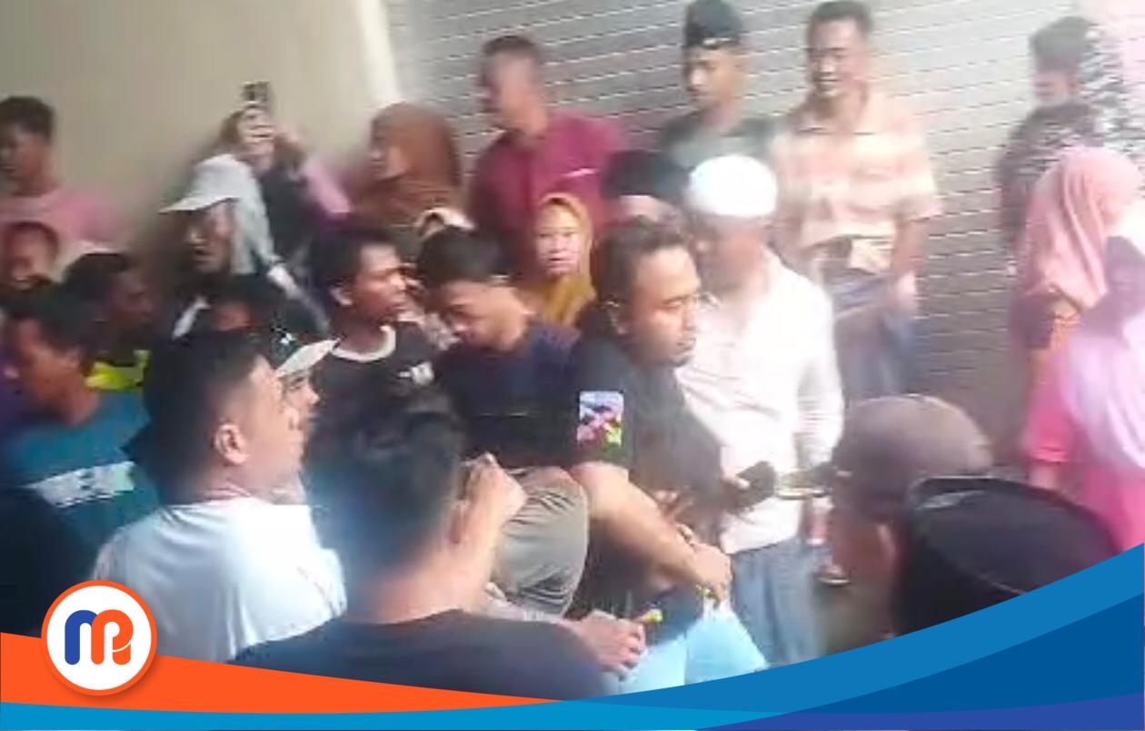 Nampak terduga pelaku pencurian (maling) dipiting oleh salah seorang anggota Polsek Sokobanah dan dikerumuni oleh warga