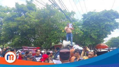 Korlap aksi Jaringan Anti Rasuah Jawa Timur melepas baju saat berorasi di atas mobil komando