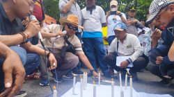 Peserta aksi menyalakan lilin di deoan Mapolda Jawa Timur