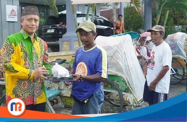Direktur Utama BPRS Bhakti Sumekar, H. Hairil Fajar saat berbagi takjil kepada salah satu tukang becak Senin (17/03/2025)