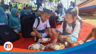 Siswa SD sedang menikmati makanan dengan lauk ikan laut di kegiatan Germarikan