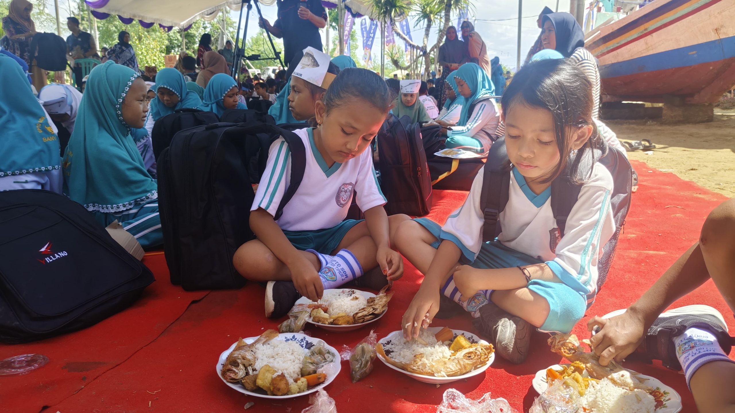 Siswa SD sedang menikmati makanan dengan lauk ikan laut di kegiatan Germarikan