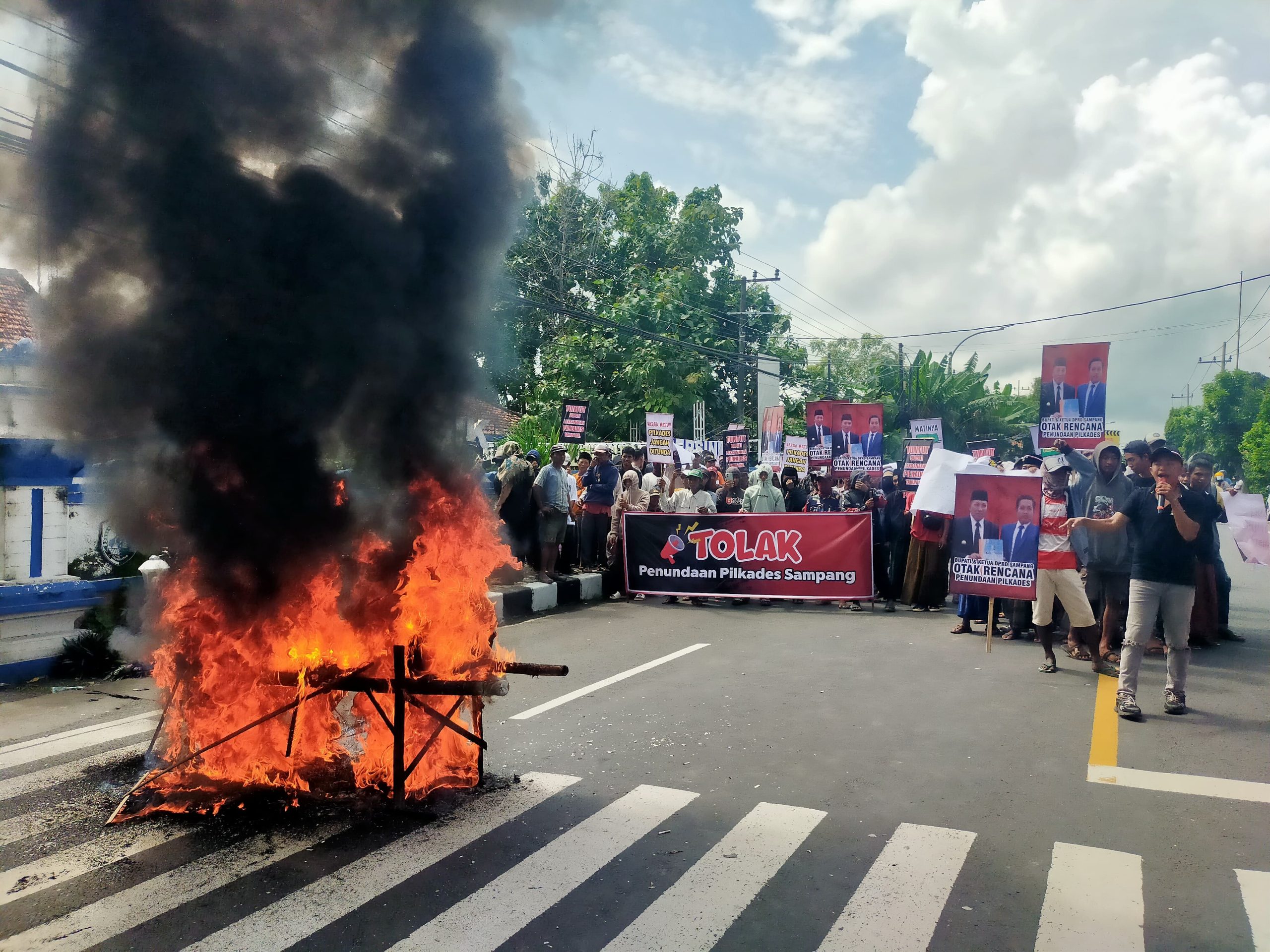 Pendemo membakar keranda mayat sebagai simbol matinya demokrasi di desa-desa Sampang