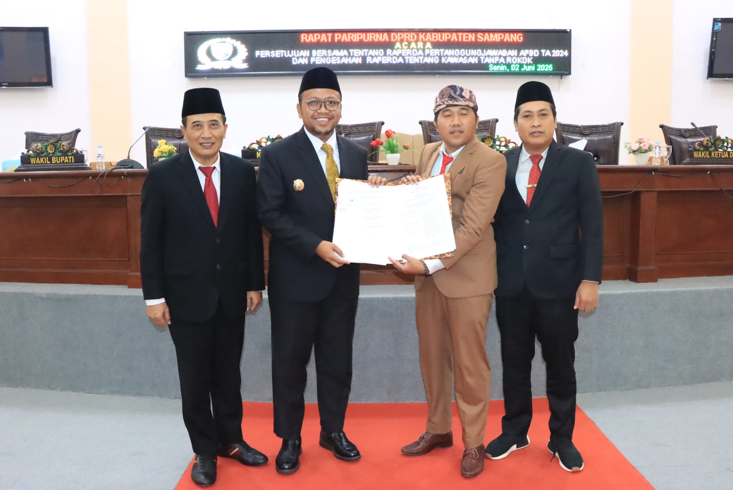 Wakil Ketua DPRD Sampang, Muhammad Iqbal Fathoni, dan Wakil Bupati Sampang Ahmad Mahfudz (ditengah), menunjukkan pengesahan Raperda