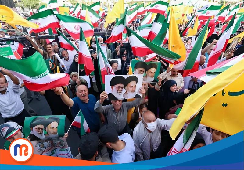Warga Iran meneriakkan slogan-slogan, mengibarkan bendera nasional, dan memegang potret Pemimpin Tertinggi Iran Ayatollah Ali Khamenei (kiri) dan mendiang Pemimpin Tertinggi Ayatollah Ruhollah Khomeini, saat mereka merayakan gencatan senjata antara Iran dan Israel di Lapangan Enghelab di ibu kota Teheran pada 24 Juni 2025.